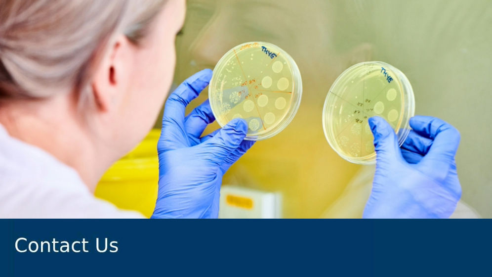 Technician working in a lab with two petri dishes